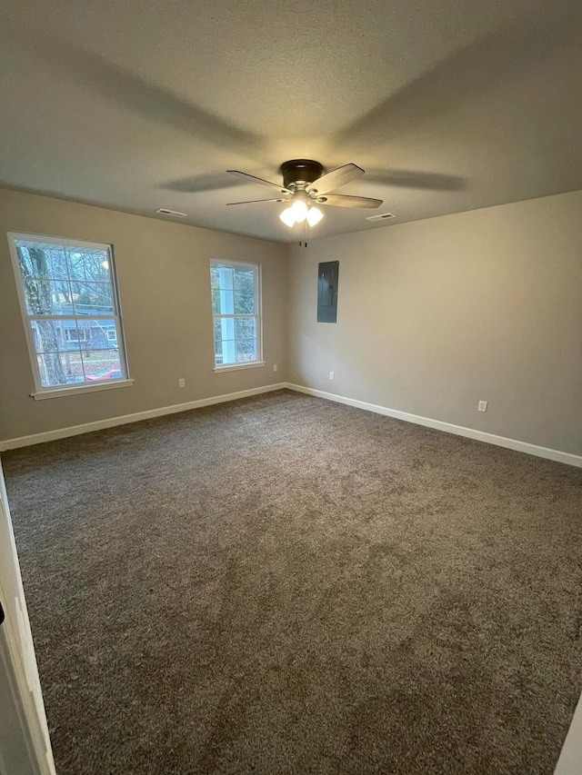 carpeted empty room featuring electric panel, ceiling fan, and a textured ceiling