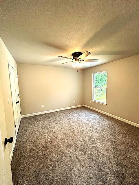908 7th St, Boonville, MO 65233 - empty room featuring a ceiling fan, carpet flooring, baseboards, and a textured ceiling