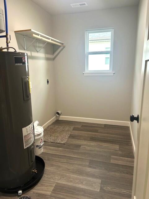 908 7th St, Boonville, MO 65233 - laundry area with water heater, baseboards, hookup for an electric dryer, and wood finished floors