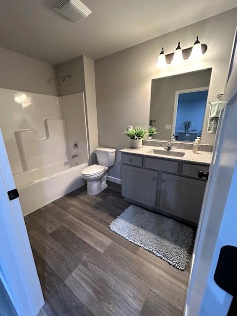 908 7th St, Boonville, MO 65233 - full bath featuring toilet, tub / shower combination, vanity, and wood finished floors