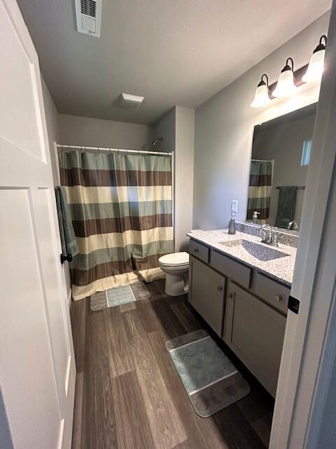 908 7th St, Boonville, MO 65233 - full bathroom featuring wood finished floors, vanity, toilet, and curtained shower