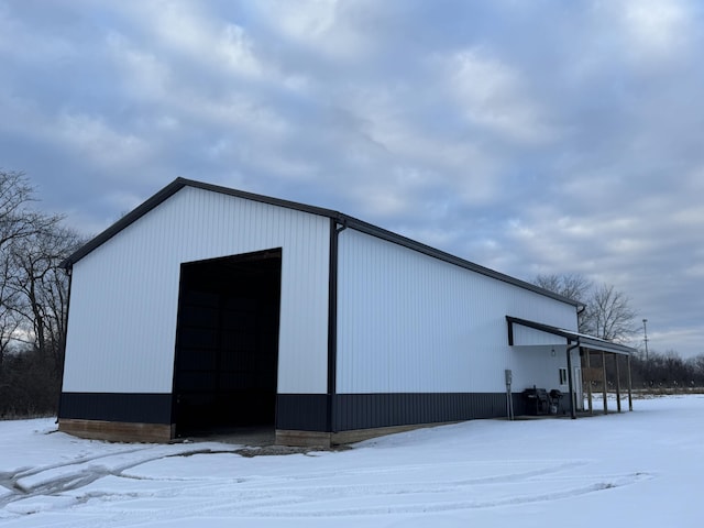 snow covered structure featuring a garage