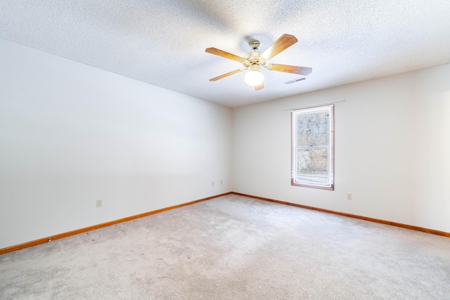 carpeted spare room with a textured ceiling and ceiling fan