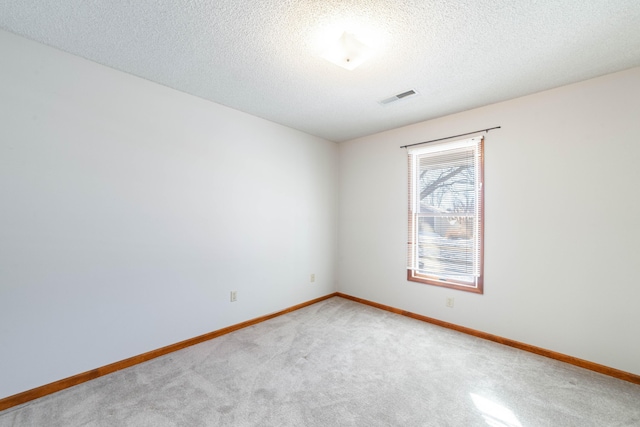 empty room featuring a textured ceiling and carpet