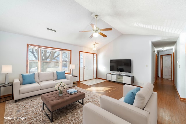 living room featuring ceiling fan, hardwood / wood-style floors, and lofted ceiling