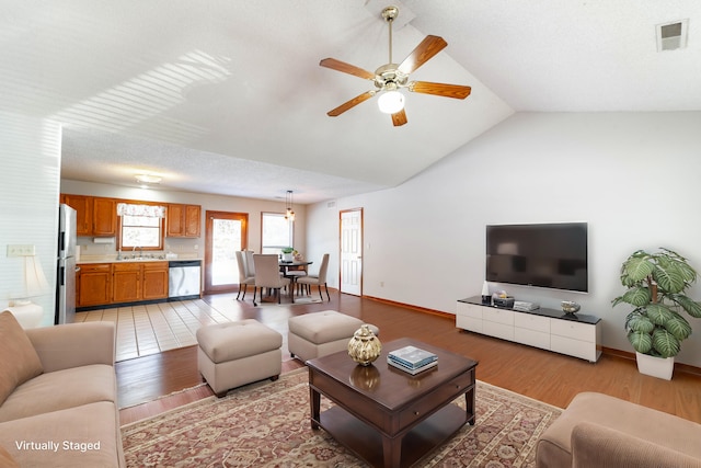 living room with vaulted ceiling, ceiling fan, light hardwood / wood-style floors, and sink