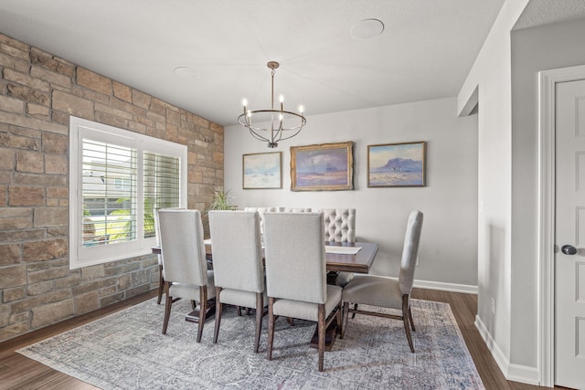 dining room with dark wood-type flooring and a chandelier