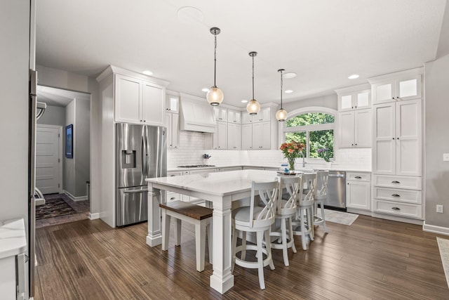 kitchen with appliances with stainless steel finishes, white cabinetry, and custom exhaust hood