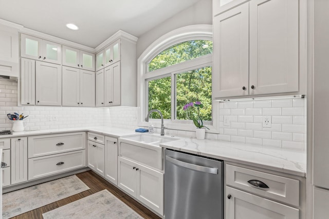 kitchen with light stone countertops, dishwasher, sink, dark hardwood / wood-style floors, and white cabinets