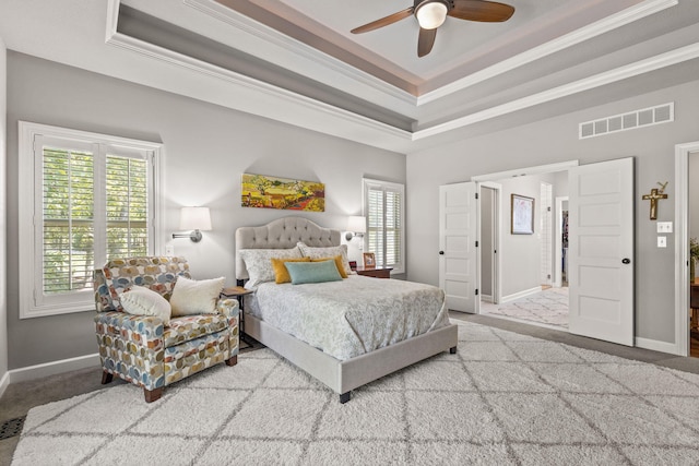 carpeted bedroom featuring a raised ceiling, ceiling fan, and ornamental molding