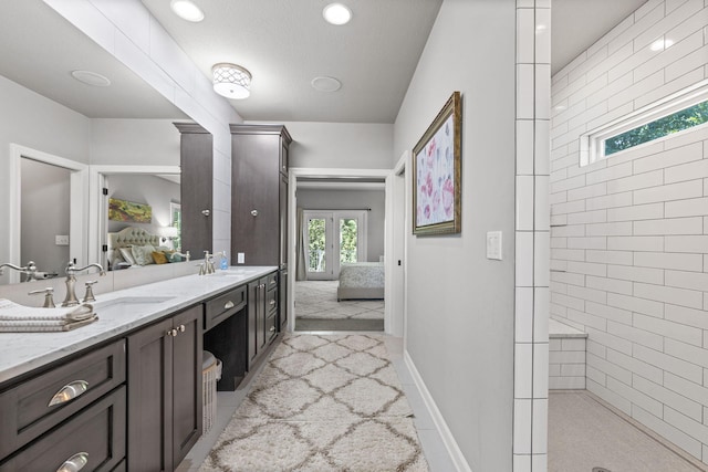 bathroom featuring a shower, french doors, and vanity