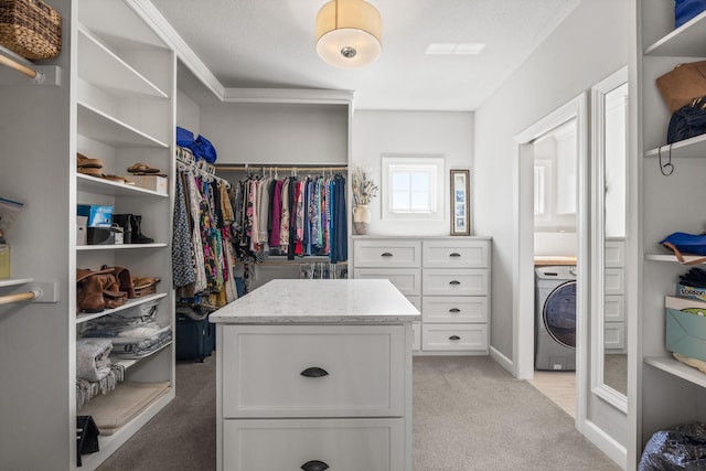 walk in closet featuring washer / clothes dryer and light colored carpet