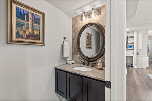 bathroom with decorative backsplash, vanity, a textured ceiling, and hardwood / wood-style flooring