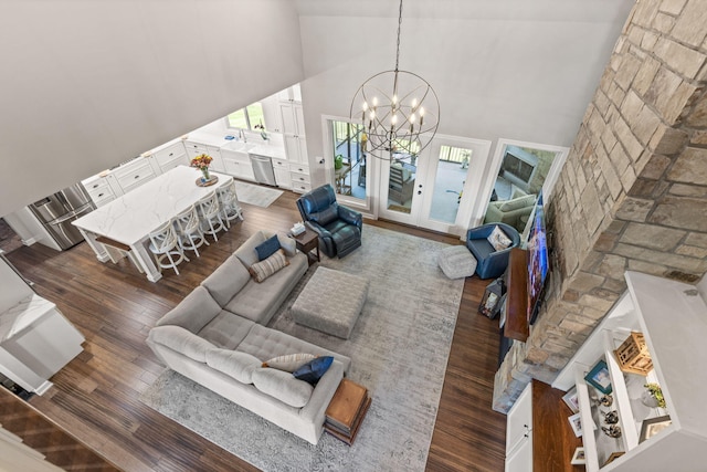 living room with a chandelier, dark hardwood / wood-style floors, and high vaulted ceiling