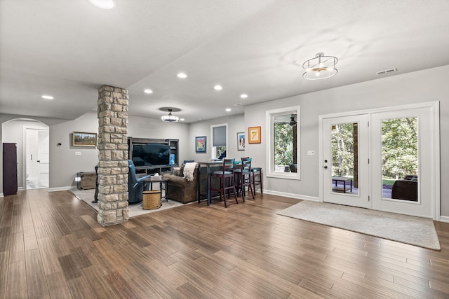 living room with wood-type flooring and ornate columns