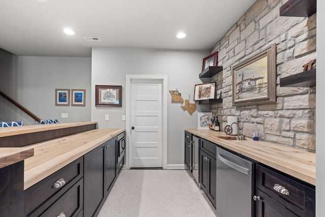 kitchen with stainless steel dishwasher, butcher block counters, and sink