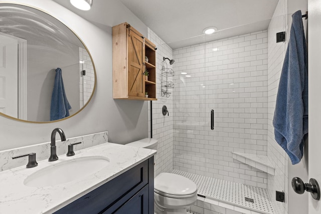 bathroom featuring vanity, toilet, and a shower with door