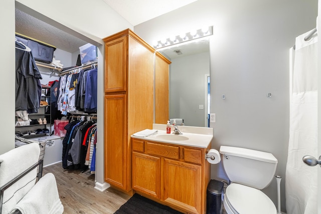 bathroom with toilet, vanity, and hardwood / wood-style floors