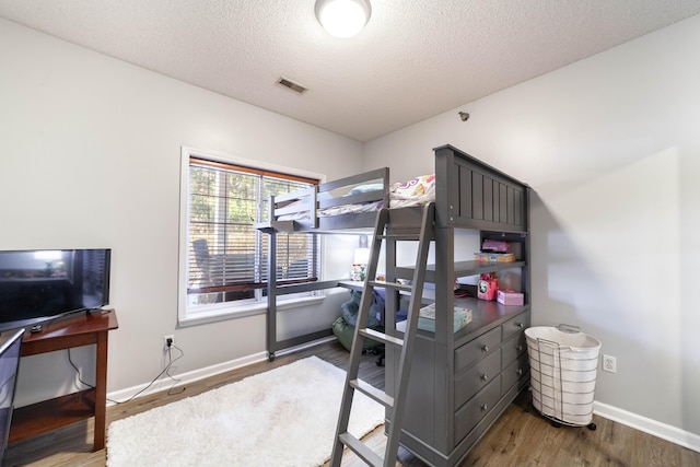 bedroom featuring a textured ceiling and hardwood / wood-style flooring