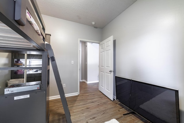 interior space with a textured ceiling and hardwood / wood-style floors