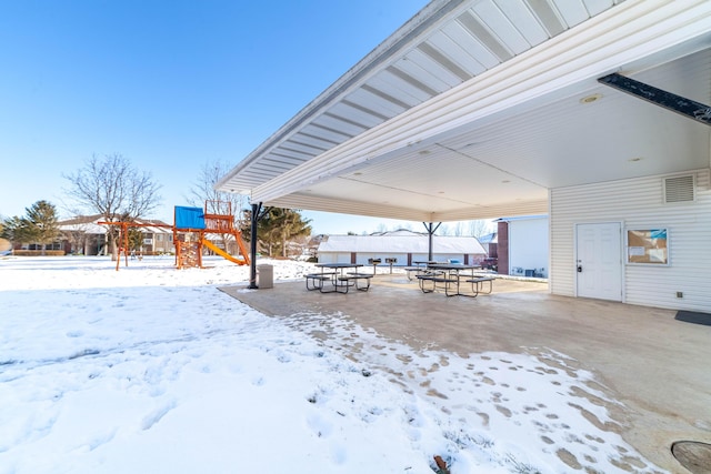 yard covered in snow featuring a playground