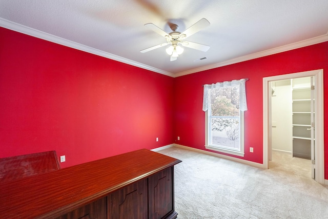 unfurnished office with ceiling fan, crown molding, and light colored carpet