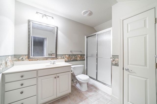 bathroom featuring tile patterned floors, vanity, toilet, vaulted ceiling, and a shower with shower door