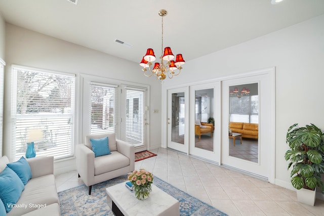 tiled living room featuring a chandelier and french doors