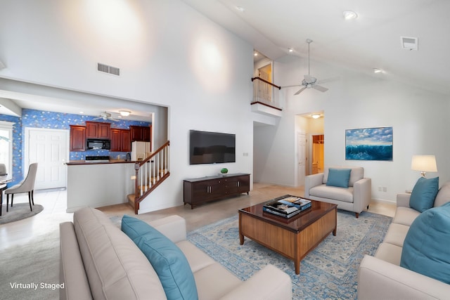 living room featuring ceiling fan and a high ceiling