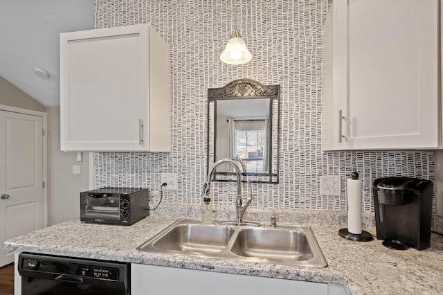 kitchen featuring pendant lighting, dishwasher, sink, white cabinets, and decorative backsplash