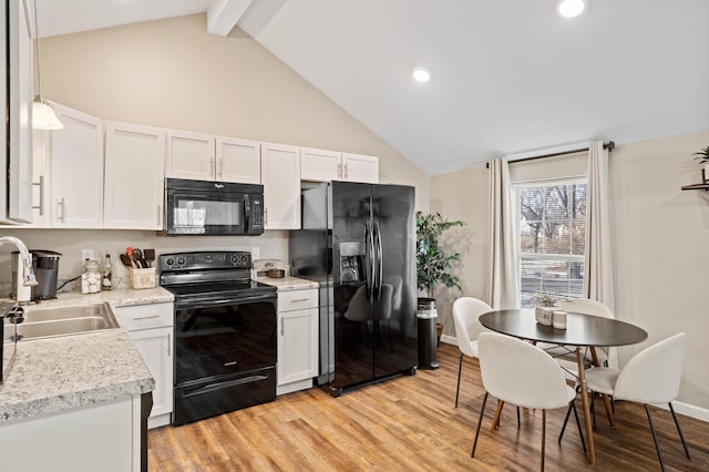 kitchen with black appliances, decorative light fixtures, white cabinets, and sink