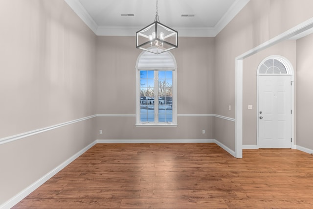 interior space featuring a notable chandelier, crown molding, and wood-type flooring