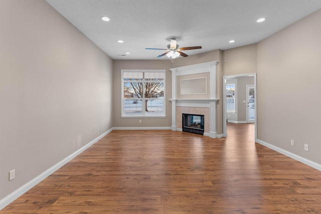 unfurnished living room featuring wood-type flooring, a fireplace, and ceiling fan