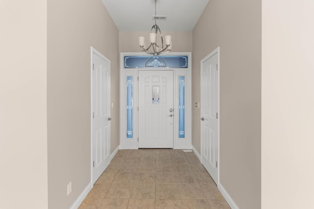 foyer with a chandelier and light tile patterned floors