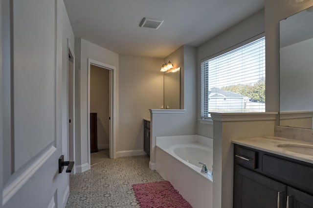 bathroom featuring a bath, a wealth of natural light, and vanity