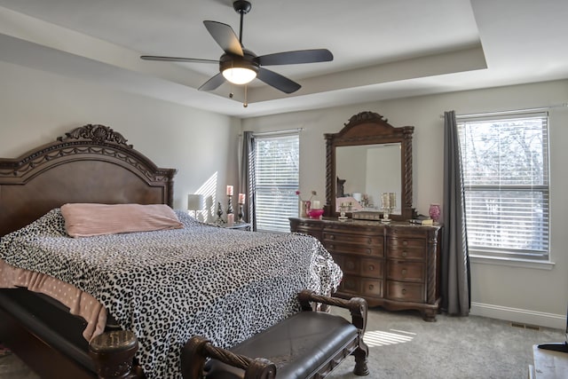 bedroom featuring carpet flooring, ceiling fan, and a tray ceiling