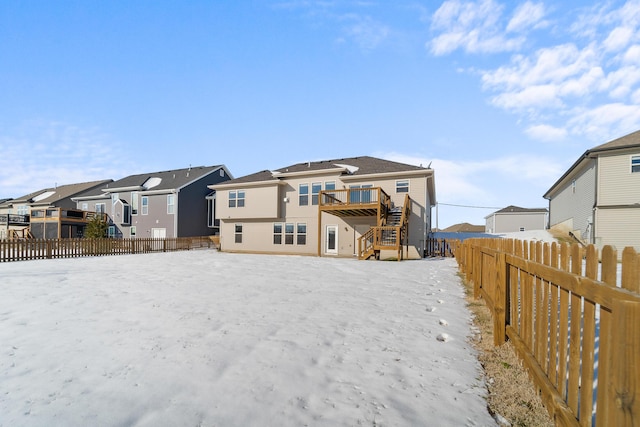 snow covered rear of property featuring a wooden deck