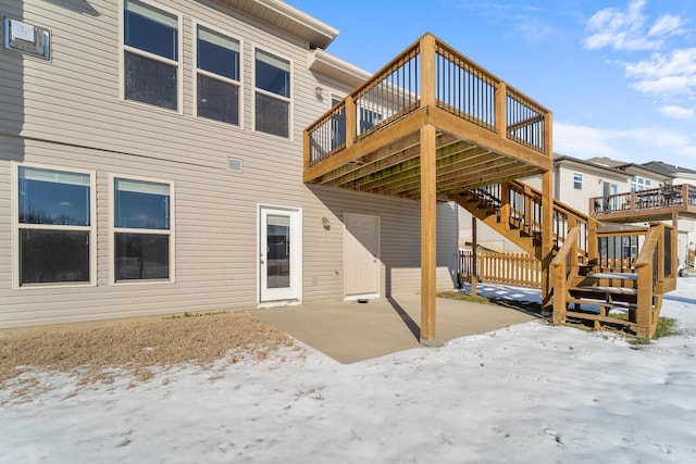 snow covered house with a deck