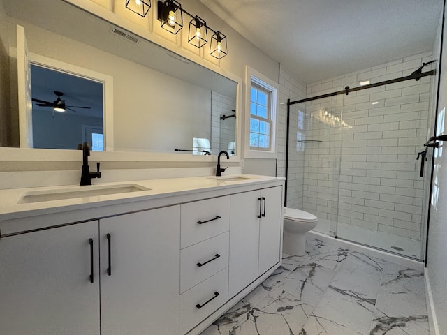 bathroom featuring ceiling fan, an enclosed shower, vanity, and toilet