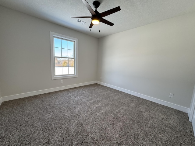 empty room with ceiling fan, dark carpet, and a textured ceiling