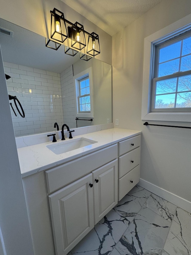 bathroom featuring a textured ceiling, a wealth of natural light, and vanity