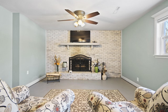 living room with a brick fireplace, concrete flooring, and ceiling fan