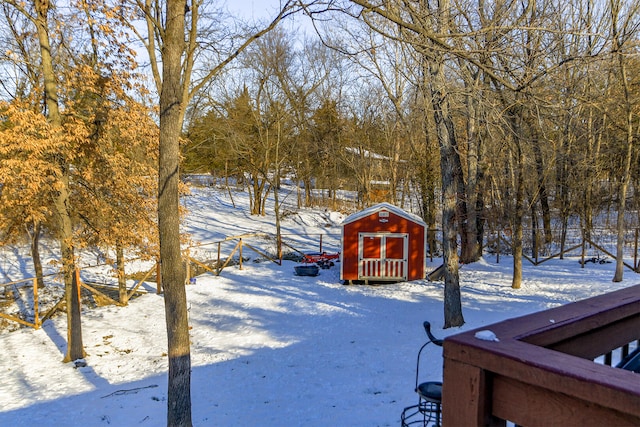 yard covered in snow featuring a shed