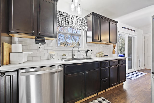 kitchen featuring sink, stainless steel dishwasher, decorative backsplash, dark brown cabinets, and dark hardwood / wood-style flooring