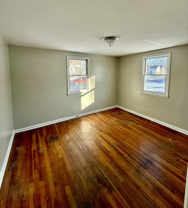 empty room with plenty of natural light and dark hardwood / wood-style floors