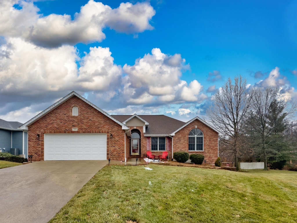 single story home with a garage and a front lawn