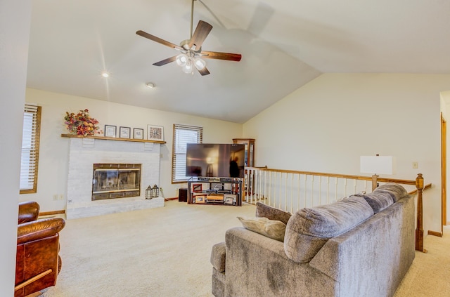 living room with ceiling fan, lofted ceiling, a brick fireplace, and light carpet