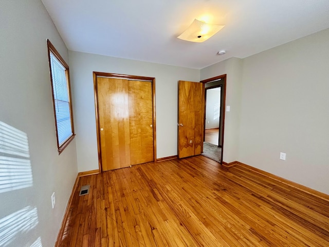 unfurnished bedroom featuring a closet and light wood-type flooring