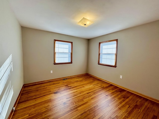 spare room with a wealth of natural light and light hardwood / wood-style flooring