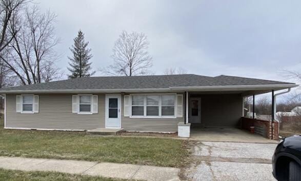 view of front of property featuring a front yard and a carport